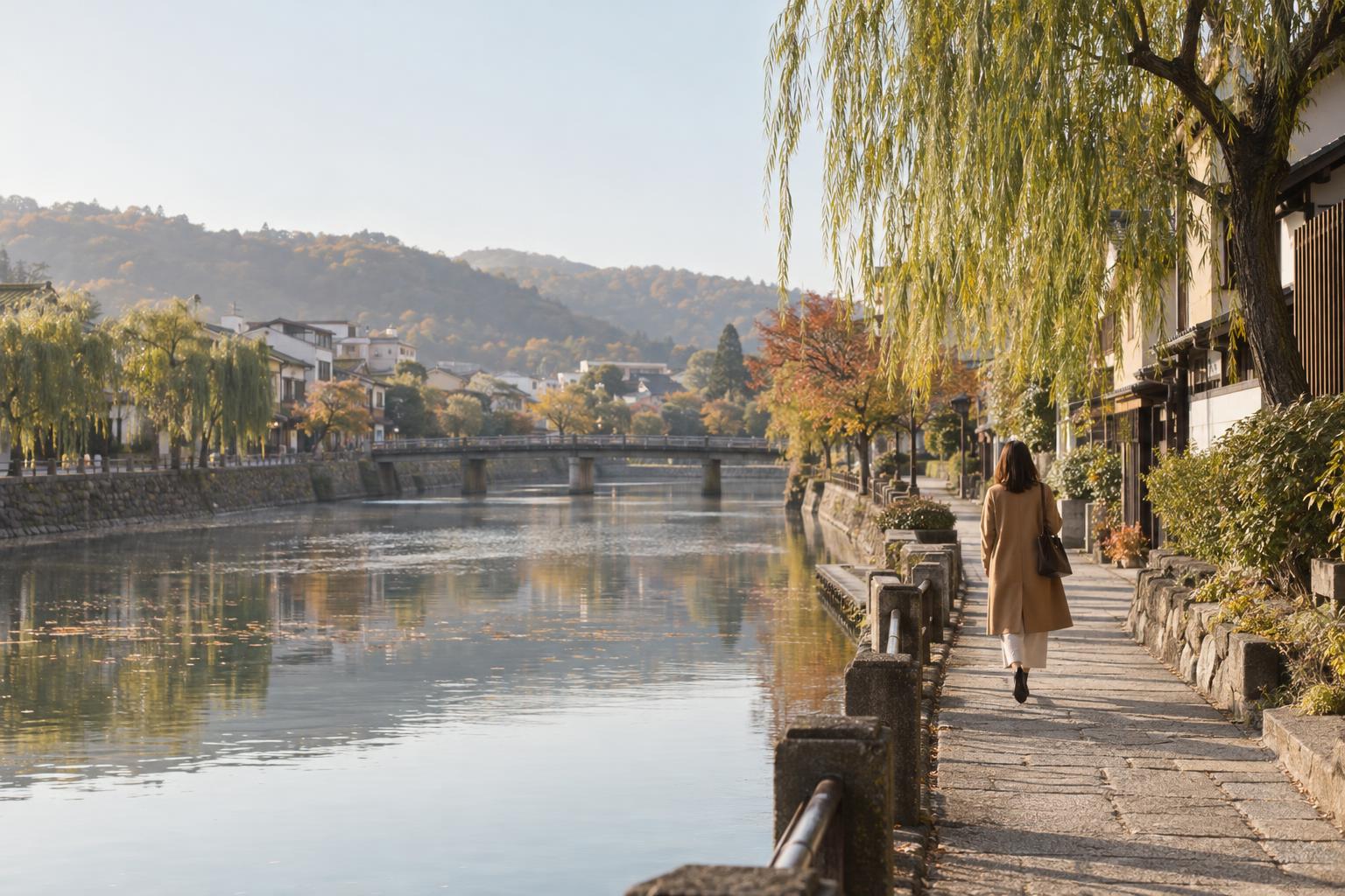 朝の川沿いの道を歩く女性